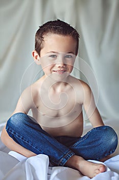 Smiling boy sitting on bed