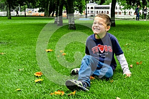 Smiling boy sitting on the grass