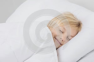 Smiling boy sleep in bed