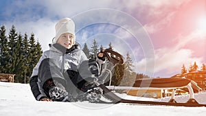 Smiling boy on snowy slope of ski mountain resort. Active winter holiday, Christmas family vacation concept. Copy space