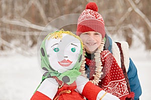 Smiling boy stands near stuffed dummy Maslenitsa