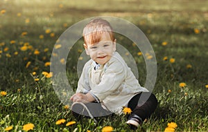 Smiling boy Todler plays on grass in summer park