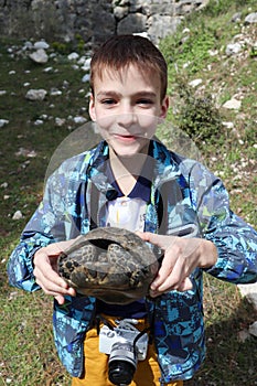 Smiling boy with turtle in his hands