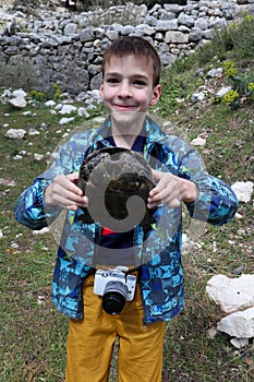 Smiling boy with turtle in his hands