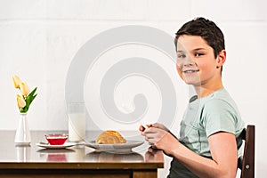 Boy using digital tablet during breakfast in kitchen