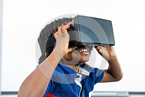 Smiling boy using virtual reality headset in classroom
