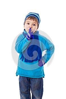 Smiling boy in winter clothes showing silence sign