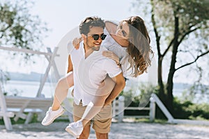 smiling boyfriend giving piggyback to girlfriend