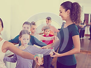 Smiling boys and girls rehearsing ballet dance in studio