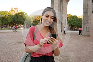 Smiling Brazilian girl using smartphone in Porto Alegre, Rio Grande do Sul, Brazil photo