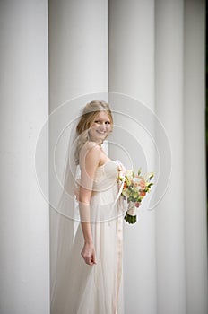 Smiling bride against a row of columns