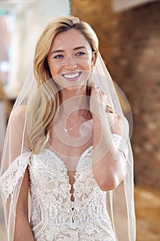 Smiling Bride In Bridal Store Trying On Wedding Dress