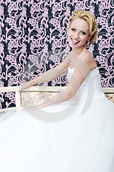 Smiling bride put out her toungue sitting bench