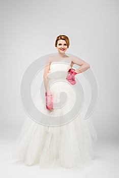 smiling bride in white wedding dress and boxing gloves