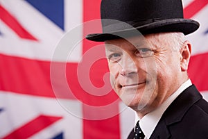 Smiling British businessman / city worker with Union Jack flag background.