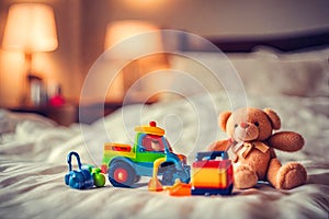 Smiling brown teddy bear sitting in bed with some other toys.