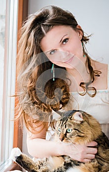 Smiling brunette girl and her cat over