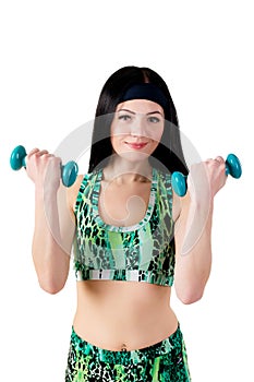 Smiling brunette girl with long hair in a green sports shirt holding a dumbbell