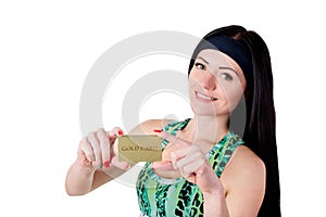 Smiling brunette girl with long hair showing gold credit card.