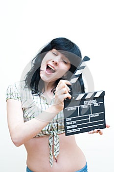 Smiling brunette girl showing clapper on white background