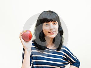 Smiling brunette girl shows red apple in her hands