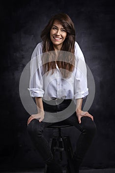 Smiling brunette haired woman looking away and cheerful smiling against isolated background