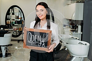 smiling brunette owner of salon standing