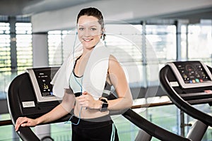 Smiling brunette on treadmill looking at the camera