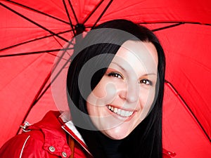 Smiling brunette woman in fall, rainproof clothes