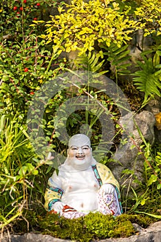 Smiling Buddha Hotey figurine in green grass