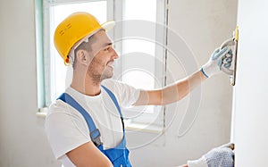 Smiling builder with grinding tool indoors