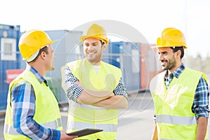 Smiling builders in hardhats with tablet pc