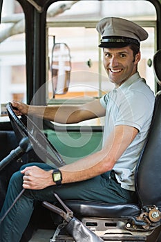 Smiling bus driver driving a bus