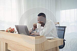 Smiling business black american man, African person working from home and drinking coffee with computer notebook laptop on webcam