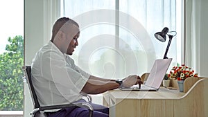 Smiling business black american man, African person working from home on table with computer notebook laptop in quarantine in