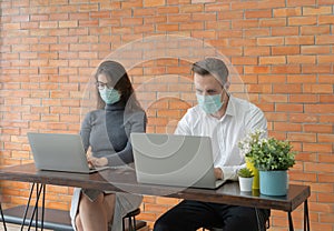 Smiling business blonde, white couple people with mask working online from home on table with computer notebook laptop on webcam