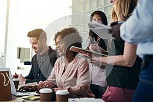 Smiling business colleagues working together at an office table