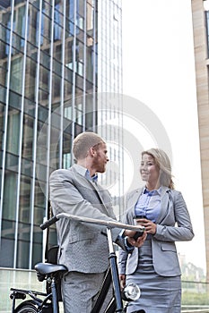 Smiling business couple talking outside office building