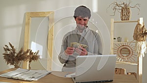 Smiling business man counts money while sitting in the office. A successful businessman earns money.