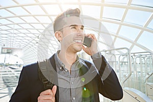 Smiling business man on mobile phone call with bag