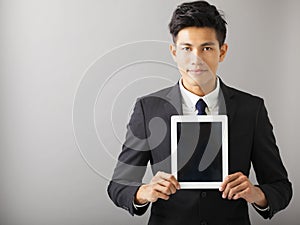 Smiling business man showing tablet pc