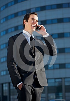 Smiling business man talking on mobile phone outdoors