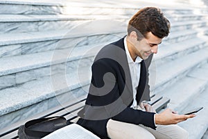 Smiling business man using mobile phone