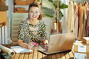 Smiling business owner woman browsing online shop in office