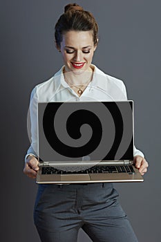 smiling business owner woman showing laptop blank screen