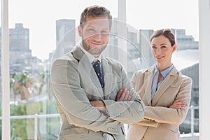 Smiling business partners with arms crossed