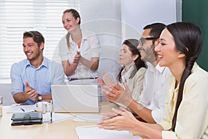 Smiling business people clapping during a meeting