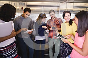 Smiling business people discussing in elevator