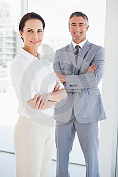 Smiling business people with folded arms