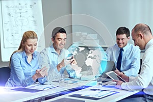 Smiling business people with gadgets in office photo